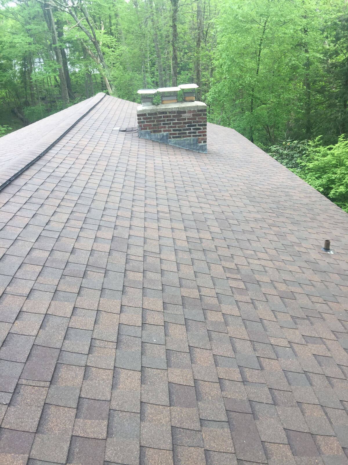New shingle roof on a wooded property