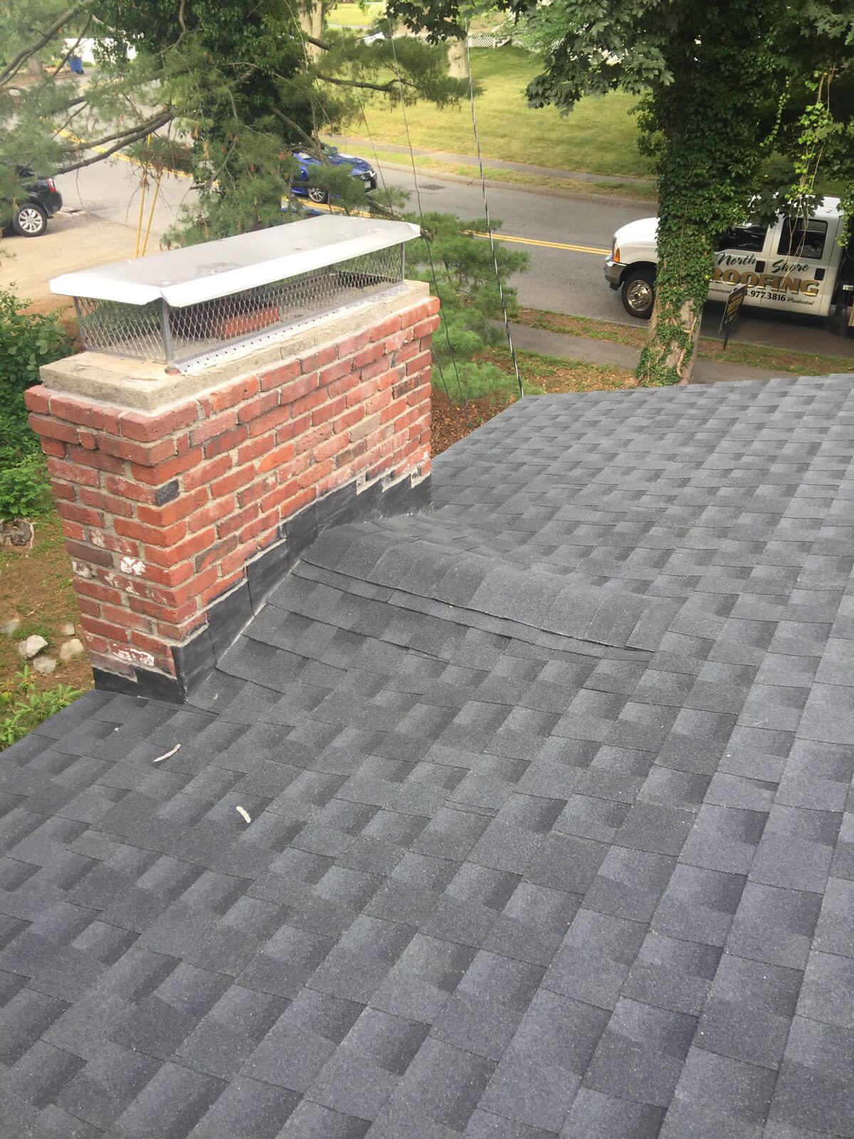 Brick chimney with new cap and counter-flashing